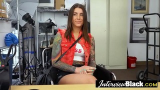 Sexy tattooed babe is deep throating a huge black cock at a fake casting.